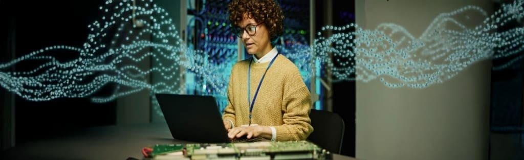 An IT professional working on a laptop in a data center, with glowing digital waves representing data flow and advanced technology, emphasizing innovation and AI-driven infrastructure.